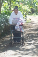 A proud recipient of a new walker takes at stroll on the Hogar grounds.