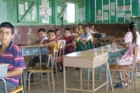Students sit proudly in their new desks.