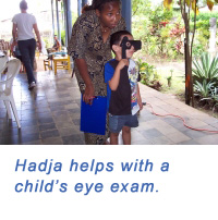 Hadja helps with child's eye exam.